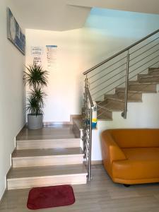 a staircase with a orange couch and a stair case at Villa Elisabeth in Lignano Sabbiadoro