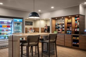 a restaurant with a bar with stools and a refrigerator at Candlewood Suites Mobile-Downtown, an IHG Hotel in Mobile