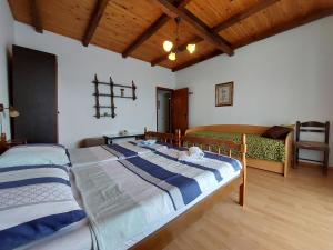 a bedroom with two beds in a room with wooden ceilings at Apartments Vilim in Pinezici