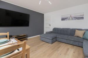 uma sala de estar com um sofá e uma televisão em Dedala Apartment 300m to the Beach by Renters em Gdynia