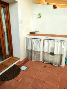 a kitchen with a counter with curtains on it at Casa Patrizia in Olbia +28 photos