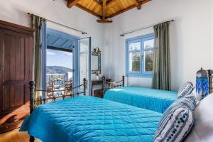 two beds in a bedroom with a window at villa Avaton near Skopelos town in Skopelos Town