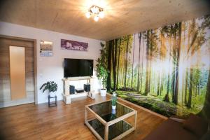 a living room with a large wall mural of trees at Daheim im Geissetal in St. Blasien