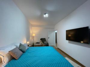 a bedroom with a large blue bed with a flat screen tv at Luxury Q Residence near Palas Mall in Iaşi