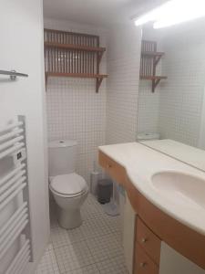 a white bathroom with a toilet and a sink at Petit loft face rivière in Collobrières