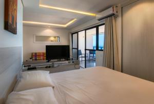 Schlafzimmer mit einem Bett und einem Flachbild-TV in der Unterkunft Particular Iracema Residence in Fortaleza