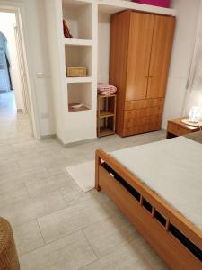 a bedroom with a bed and a wooden cabinet at Casa Patrizia in Olbia