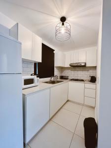 維拉阿連德的住宿－HOUM alojamientos, NORTH GREEN，厨房配有白色橱柜和白色冰箱。