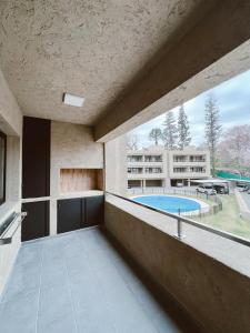 an indoor balcony with a pool and a building at HOUM alojamientos, NORTH GREEN in Villa Allende
