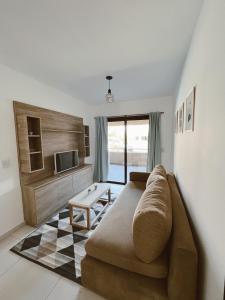 a living room with a couch and a tv at HOUM alojamientos, NORTH GREEN in Villa Allende