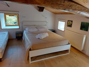 1 dormitorio con 1 cama con 2 toallas en La cambuse des gones - Gîte 3 chambres, en Thurins