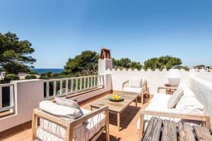 a patio with a table and chairs and the ocean at Villa Hércules 115 Binidali in Cap d'en Font