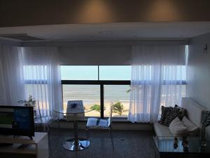a living room with a large window with a view of the beach at Particular Iracema Residence in Fortaleza