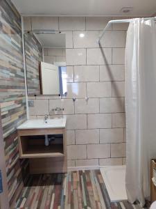 a bathroom with a sink and a mirror at cocon des lys in Saint-Louis