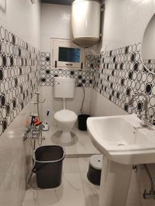 a white bathroom with a sink and a toilet at Farsal Villa in Srinagar +42 photos