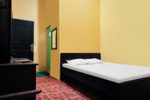 um quarto com uma cama branca num quarto em OYO 91855 Big Hotel Kendari em Kendari