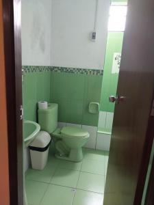 baño verde con aseo y lavamanos en Huayqui, en Lima