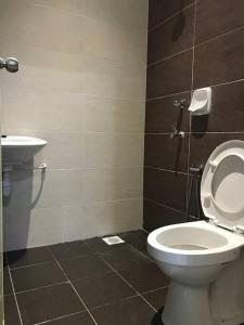 uma casa de banho com um WC e um lavatório em A Comfortable Home (Haura Homestay Kemaman) em Cukai