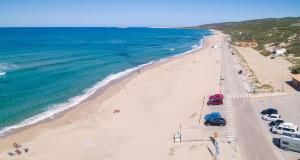 an overhead view of a beach with cars parked at Residence con piscina a Badesi, appartamenti con WIFI e A.C in Badesi