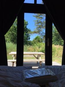 una tienda con vistas a una cama y una mesa de picnic en Tiny House in het groen, aan zee met privé Hottub, en Callantsoog