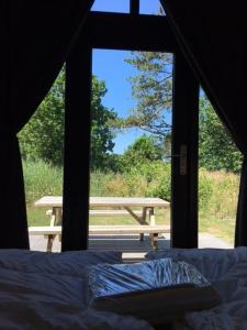 a view of a bed and a picnic table from a tent at Tiny House in het groen, aan zee met privé Hottub in Callantsoog