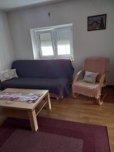 a living room with a blue couch and a chair at Apartman Duman in Livno