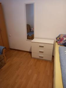 a bedroom with a bed and a dresser and a mirror at Apartman Duman in Livno