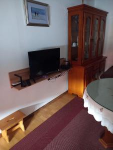 a living room with a flat screen tv and a table at Apartman Duman in Livno