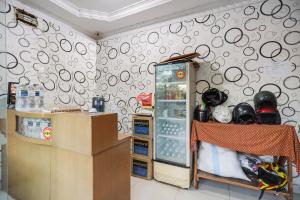 Cette chambre dispose d'un réfrigérateur et d'un mur avec des cercles. dans l'établissement SPOT ON 91887 Penginapan Rindu, à Nagoya
