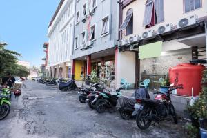名古屋的住宿－SPOT ON 91887 Penginapan Rindu，停在建筑物旁边的一排摩托车