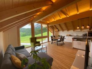 ein Wohnzimmer mit einem Sofa und einem Tisch sowie eine Küche in der Unterkunft 'dasBergblick' in Altaussee