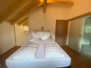 a white bed with pillows on it in a room at 'dasBergblick' in Altaussee