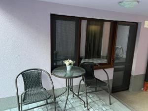 einen Tisch, zwei Stühle, einen Tisch und ein Fenster in der Unterkunft Guest House Tatiana Studio in Petrich