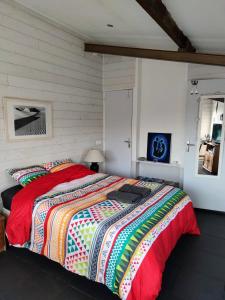 a bedroom with a large bed with a colorful comforter at Chez Daniel & Catherine in La Chevrolière