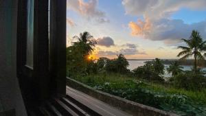a view of a sunset from a room with a window at Apto no centro de Tibau com vista para lagoa/mar in Pipa