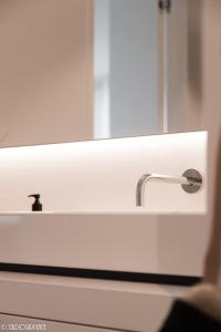 a bathroom sink with a mirror and a faucet at La Naturale Garden zeezicht in Zeebrugge