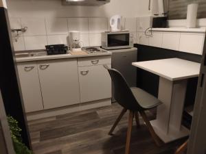 Il comprend une petite cuisine avec une chaise et un four micro-ondes. dans l'établissement Apartment Berlin Mitte, à Berlin