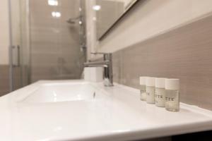 a bathroom sink with three bottles ofodorizers on a counter at Don Ciccio alla Stazione in Naples