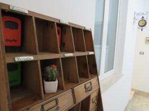 a wooden book shelf with a potted plant in it at Casa Veneto in Mazara del Vallo