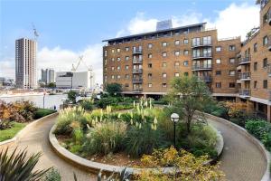 um jardim no meio de uma cidade com um edifício em Meridian Stays Canary Wharf Close to Excel and O2 em Londres