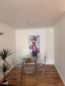 a table and chairs in a room with a painting at Meridian Stays Canary Wharf Close to Excel and O2 in London