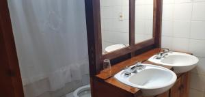 a bathroom with two sinks and a mirror and a toilet at Cabañas Trabunche in San Martín de los Andes