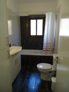 a bathroom with a sink and a toilet and a tub at LE CAROUBIER splendid 3 bedrooms bungalow in Zanaja