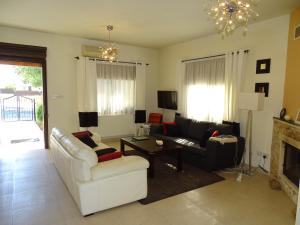 LE CAROUBIER splendid 3 bedrooms bungalow في Zanaja: غرفة معيشة مع أريكة ومدفأة