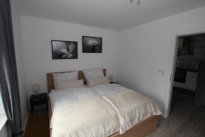 a bed in a bedroom with two pictures on the wall at 2 Exklusive Ferienwohnungen an der Nordsee in Bremerhaven