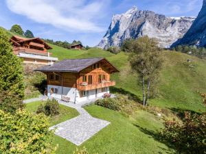 een huis op een heuvel met een berg op de achtergrond bij Apartment Mühlegaden 5.5 - GRIWA RENT AG in Grindelwald