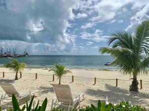 una playa con sillas, palmeras y el océano en REEF Beachfront 3BDR apartment by CASA PARAISO, en Cancún