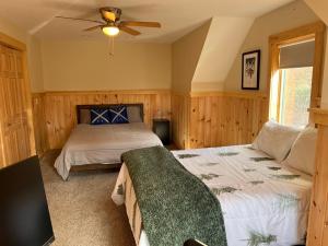 een slaapkamer met 2 bedden en een plafondventilator bij Loafers' Lodge in Carrabassett