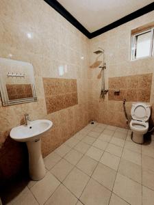 y baño con lavabo y aseo. en Haika Home Lodge, en Dar es Salaam