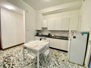 uma cozinha branca com uma mesa e um frigorífico em B&B Dai Nonni em Verona